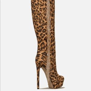 An over-the-knee platform boot featuring a stiletto heel, chain fringe